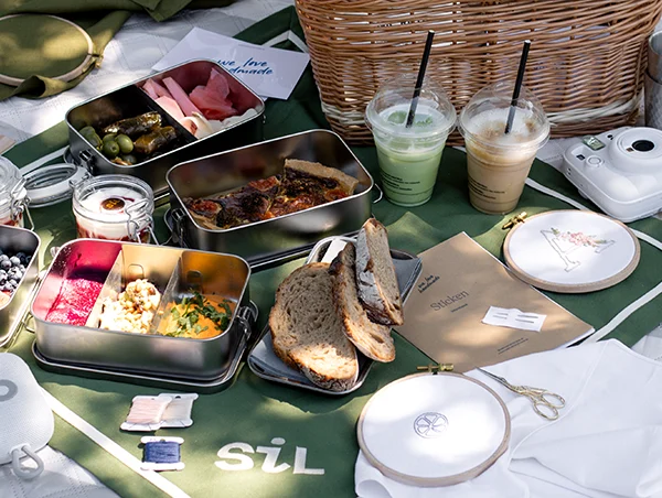 Picknickdecke im Burggarten mit SiL Tischtuch, Speisen in Edelstahldosen, Musikbox, Stickgarnen, Stickrahmen und Stick-Workbook